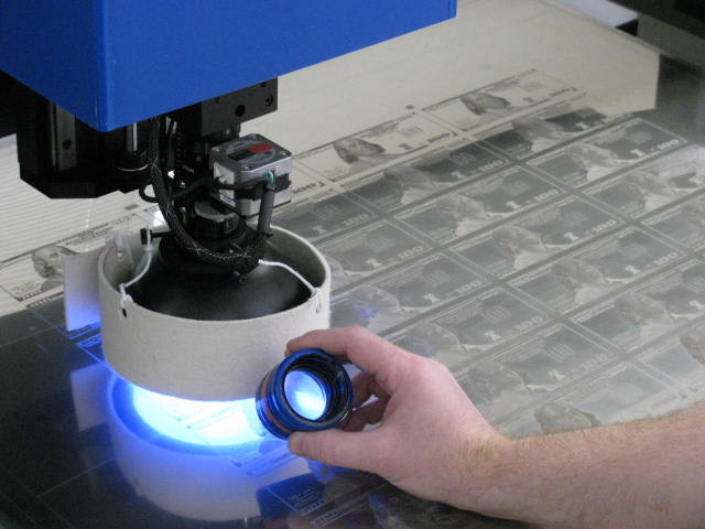 A siderographer examines a $100 plate.
