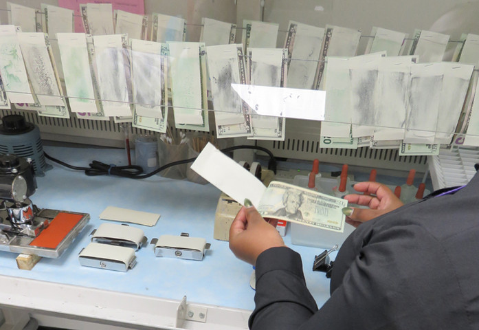 Notes undergoing chemical rub testing in the Quality Assurance Division laboratory.