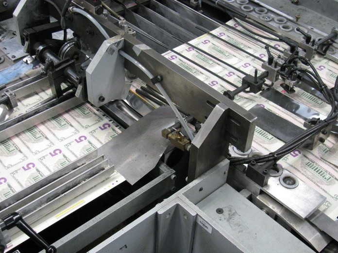 A unit of 100 $1 notes is banded before it is packaged.